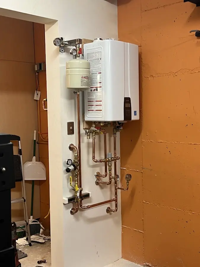 Plumbing technician inspecting water heater connections in Whiteville